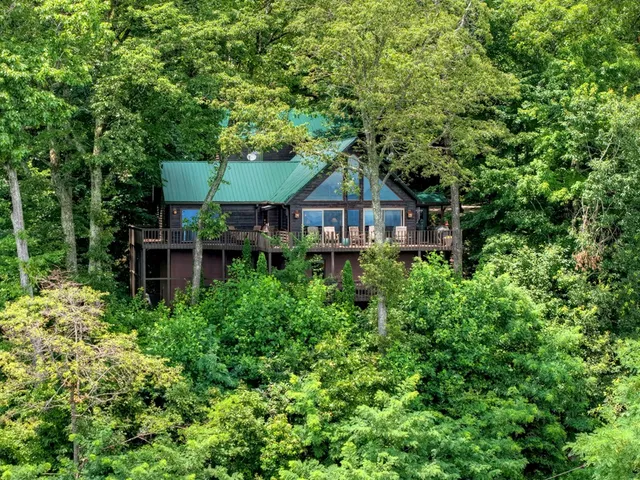 a living room with furniture a flat screen tv and a floor to ceiling window