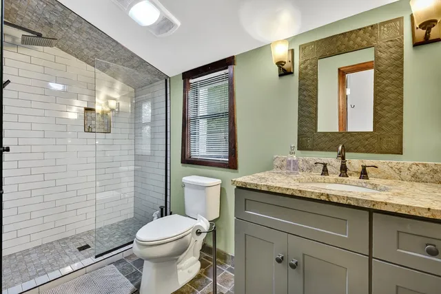 a bathroom with a granite countertop sink vanity and mirror