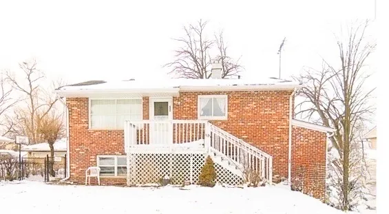 a front view of a house with a large tree