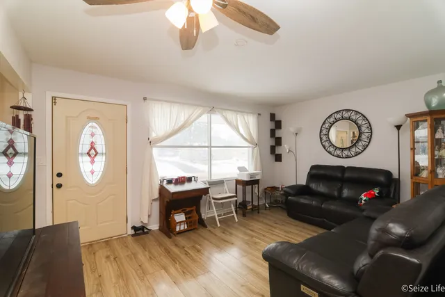 a living room with furniture a window and a clock