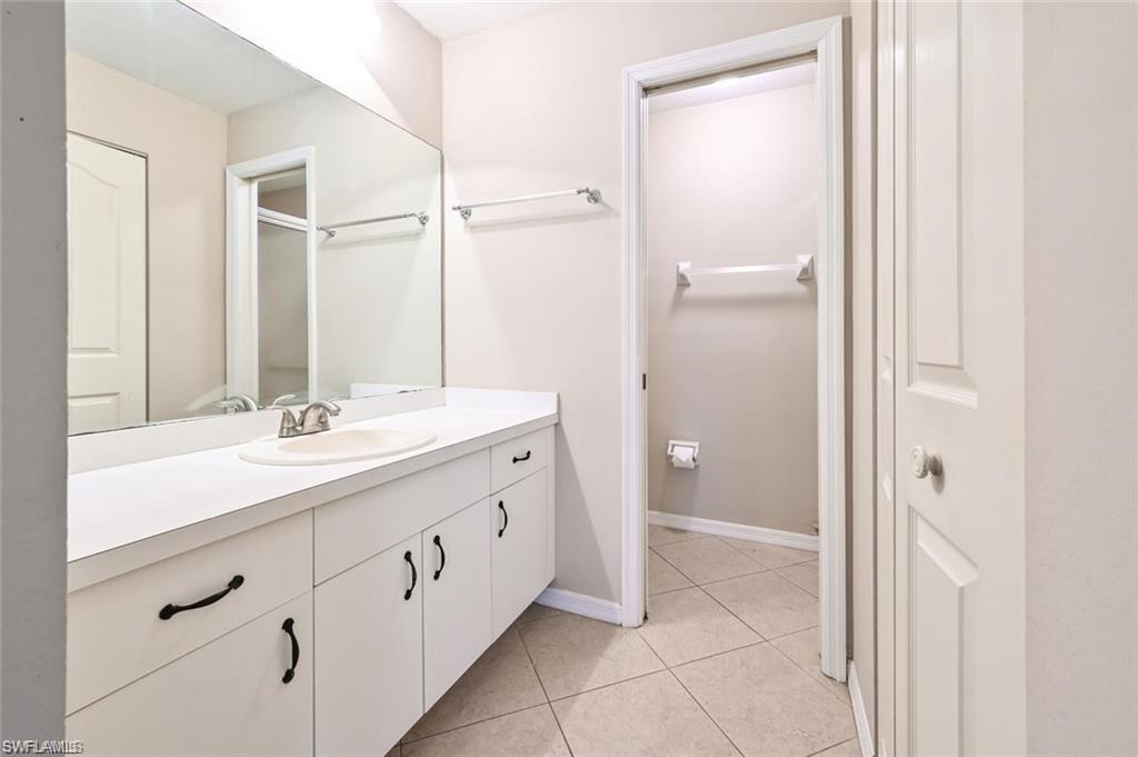 494 St Andrews Boulevard, Unit 14 Naples, FL 34113 - Photo 9 of 9 a bathroom with a double vanity sink and mirror
