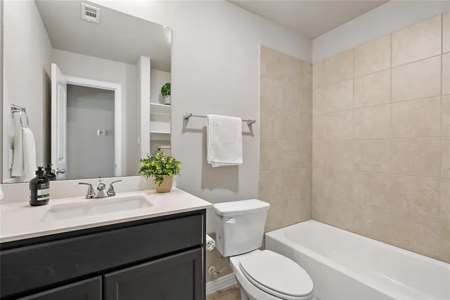 a bathroom with a sink a toilet a mirror and shower