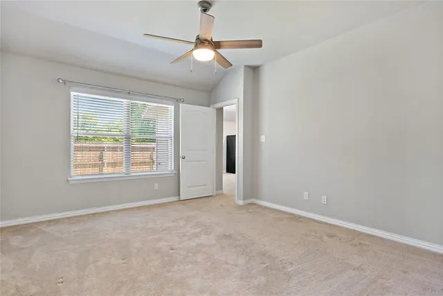 an empty room with fan and windows