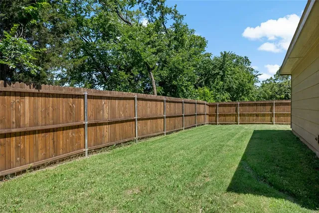 a view of a backyard with wooden fence