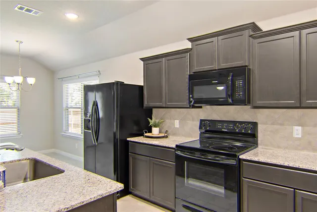 a kitchen with stainless steel appliances granite countertop a refrigerator and a sink