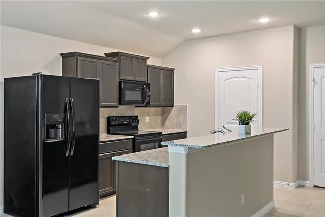 a kitchen with stainless steel appliances granite countertop a refrigerator and a stove