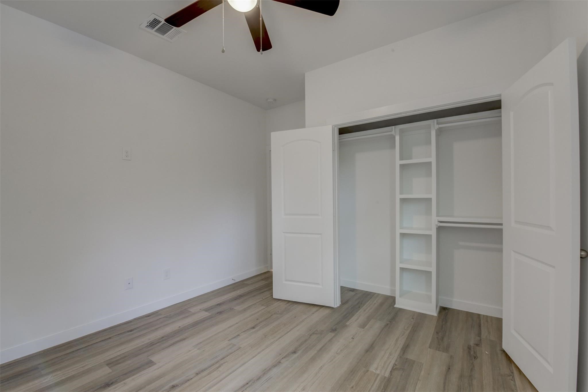 8410 Sandra Street Houston, TX 77016 - Photo 18 of 23 an empty room with wooden floor closet ceiling fan and windows