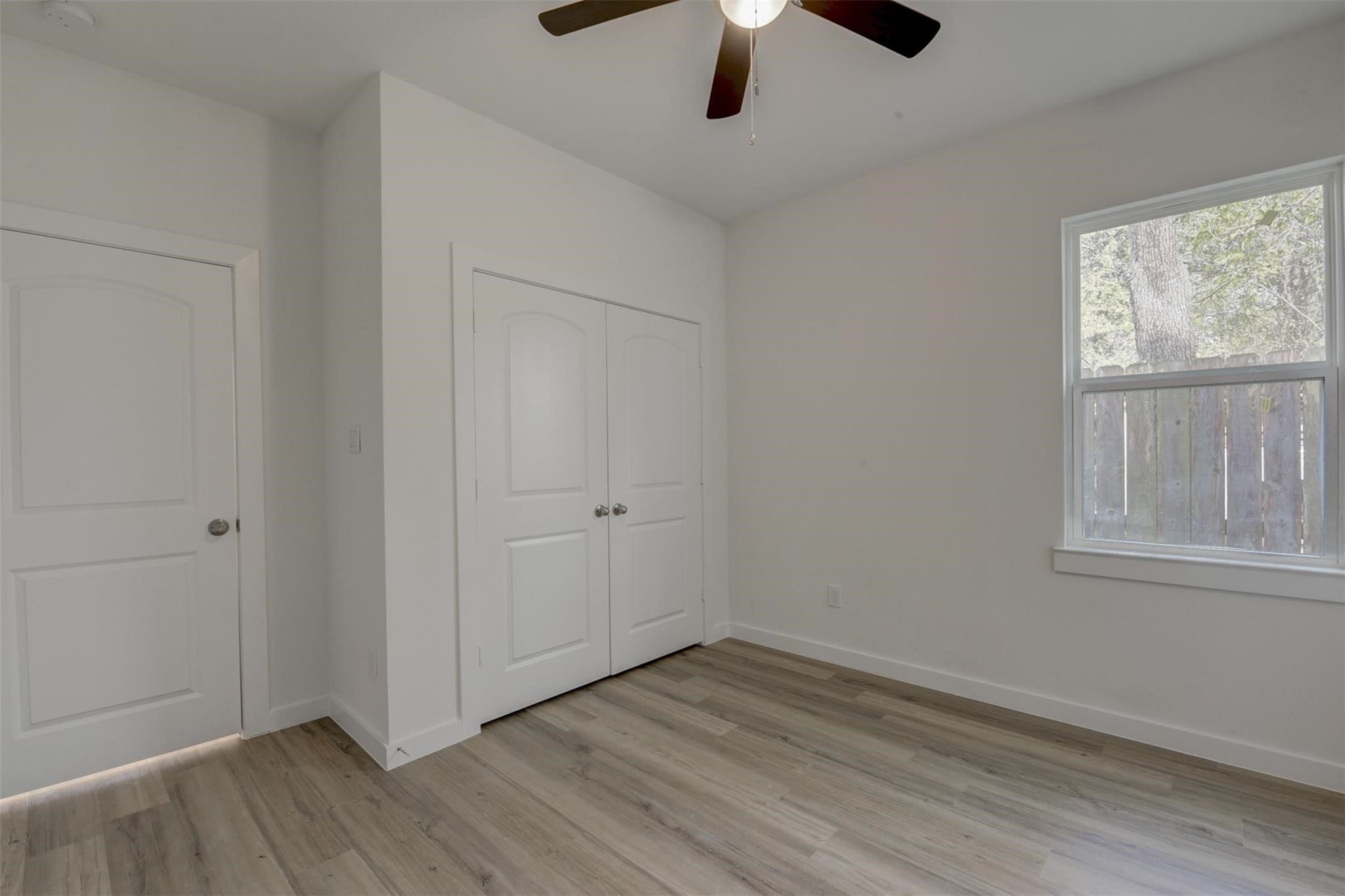 8410 Sandra Street Houston, TX 77016 - Photo 19 of 23 an empty room with wooden floor chandelier fan and windows