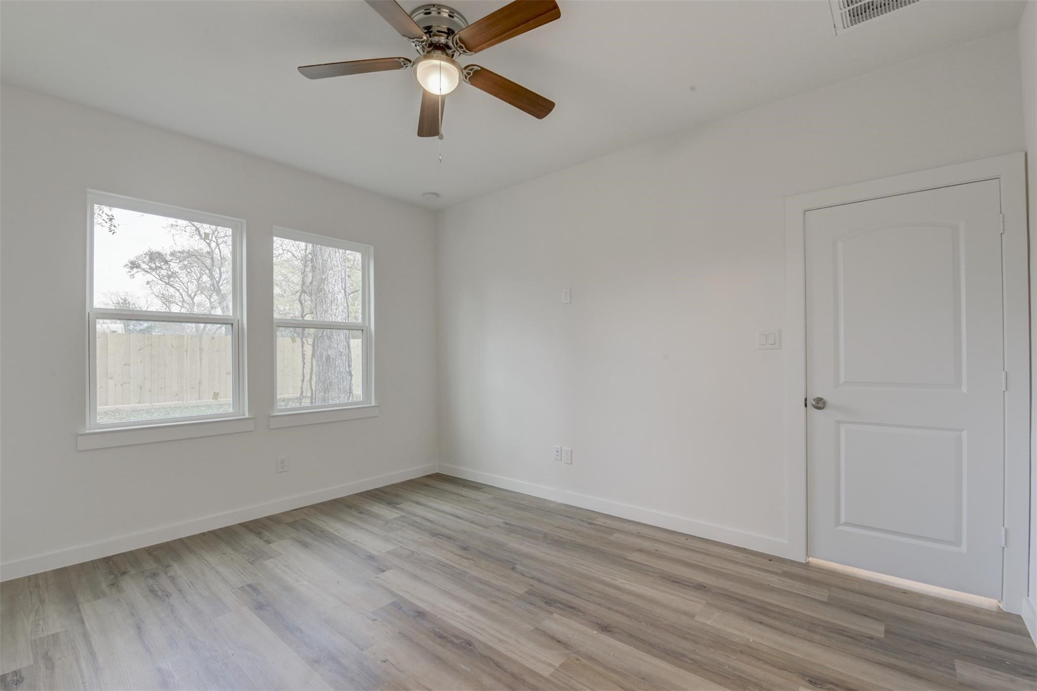 8410 Sandra Street Houston, TX 77016 - Photo 10 of 23 an empty room with wooden floor fan and windows