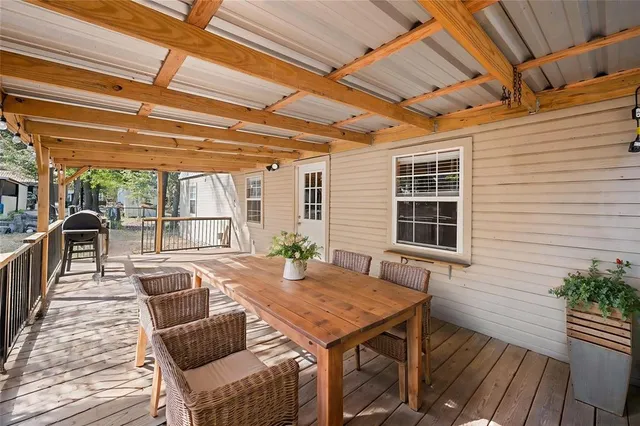 a view of a patio with table and chairs with wooden floor and plants