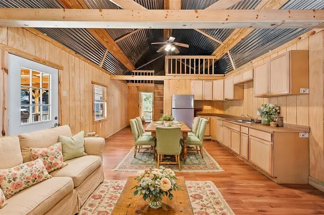 a living room with stainless steel appliances kitchen island granite countertop furniture and a rug