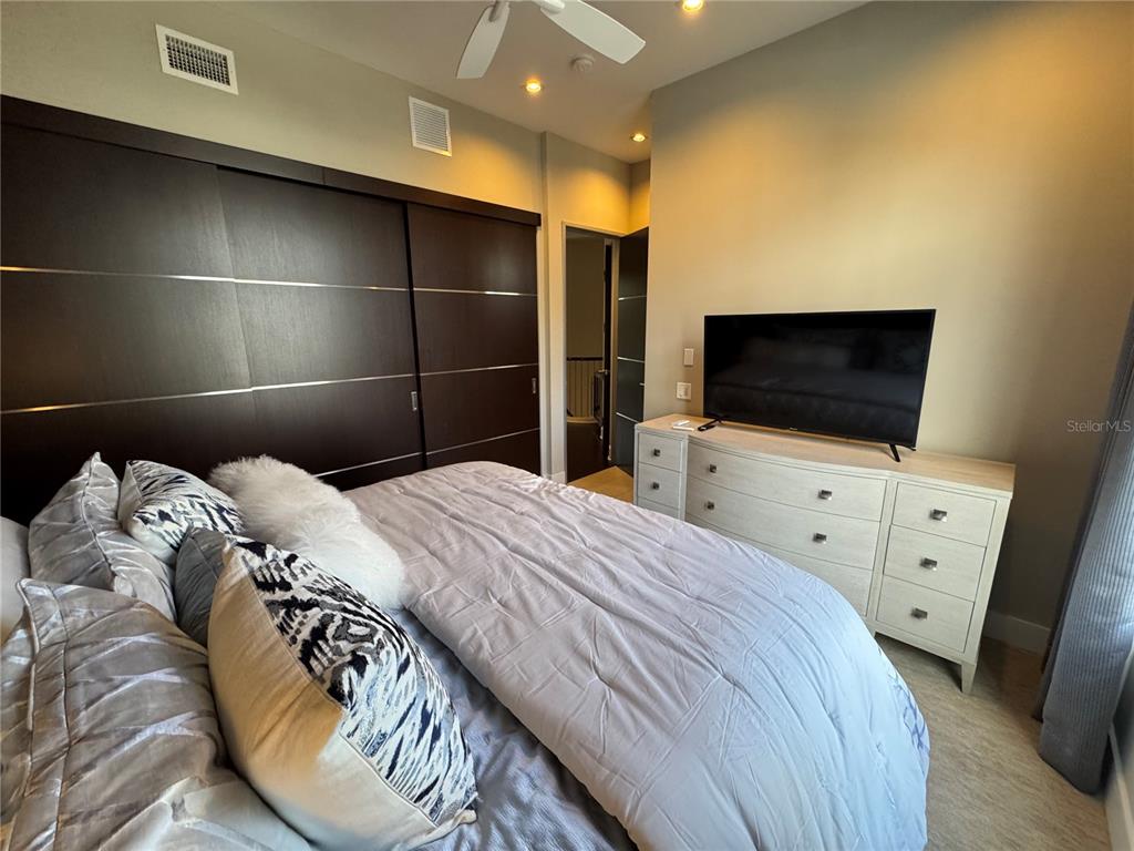 239 Cosmopolitan Court Sarasota, FL 34236 - Photo 17 of 29 a bedroom with a bed and a flat tv screen on wall