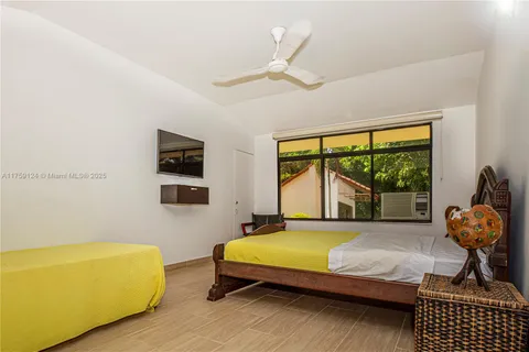 a bed sitting in a bedroom next to a window