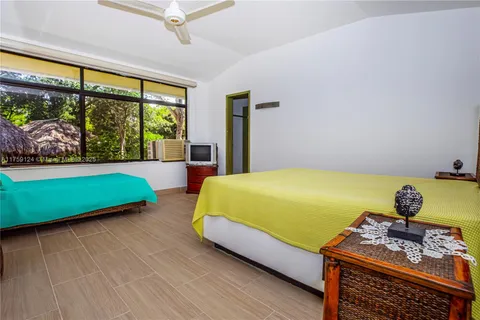 a bedroom with a bed and a flat tv screen next to a large window