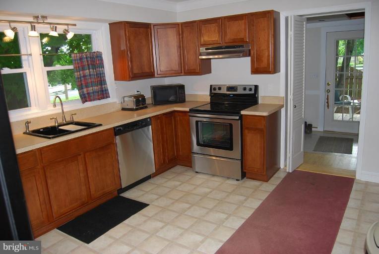 27708 Ridge Road Damascus, MD 20872 - Photo 5 of 8 a kitchen with stainless steel appliances granite countertop a sink stove and cabinets