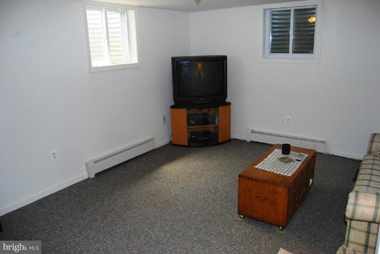 27708 Ridge Road Damascus, MD 20872 - Photo 8 of 8 a living room with furniture and a flat screen tv