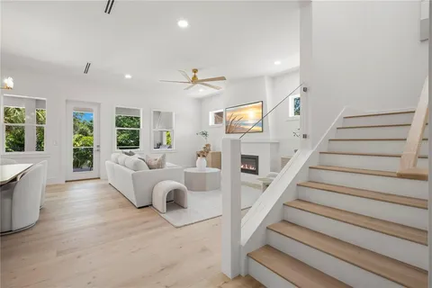 a kitchen with stainless steel appliances kitchen island granite countertop a dining table chairs refrigerator and microwave