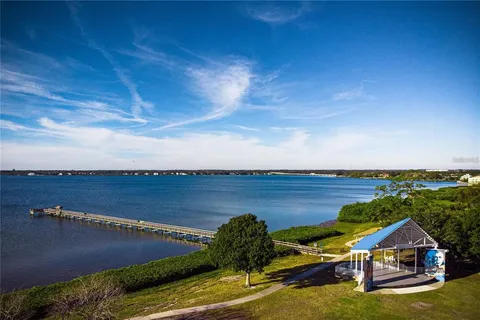 an aerial view of a house with a garden and lake view