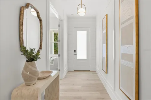 a view of a hallway with wooden floor and staircase