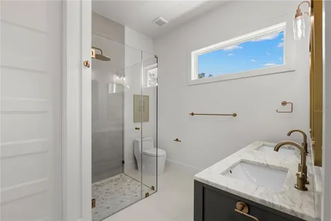 a bathroom with a sink a toilet and a mirror