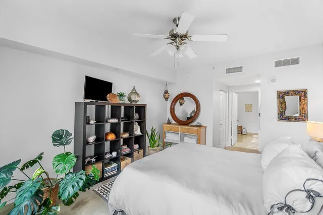 a bedroom with filled bed and a chandelier