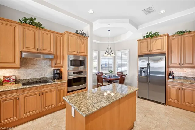 a kitchen with stainless steel appliances granite countertop a sink refrigerator and cabinets