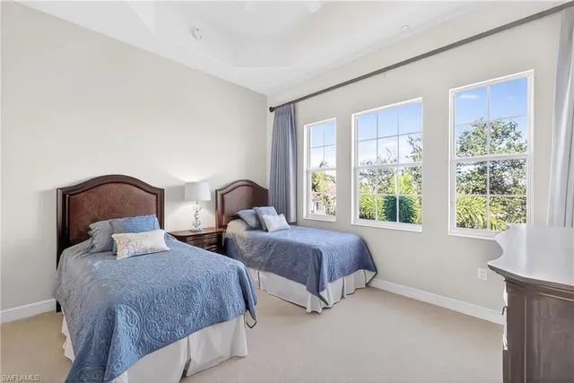 a bedroom with two beds and a large window