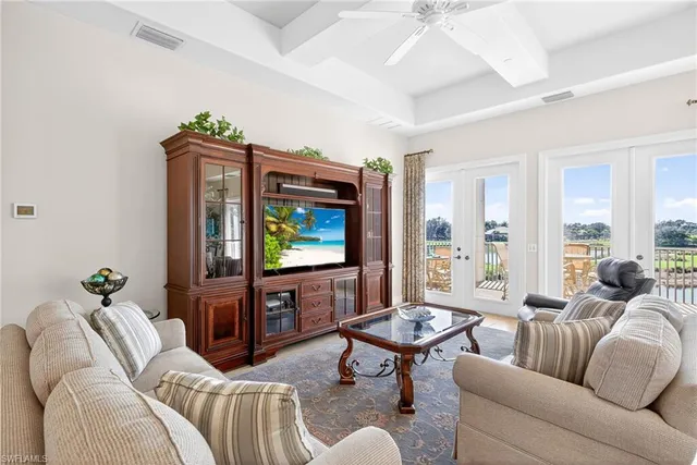 a living room with furniture a floor to ceiling window and a flat screen tv