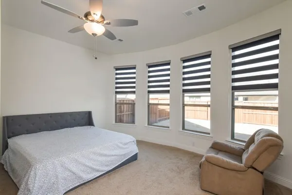 a bedroom with a large bed couch and a large window