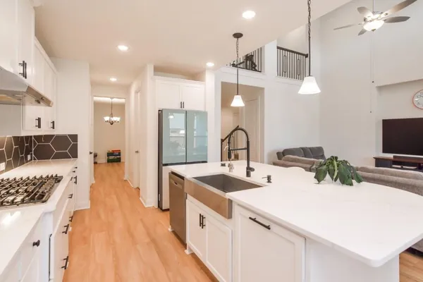 a large kitchen with kitchen island a sink appliances and a counter top space