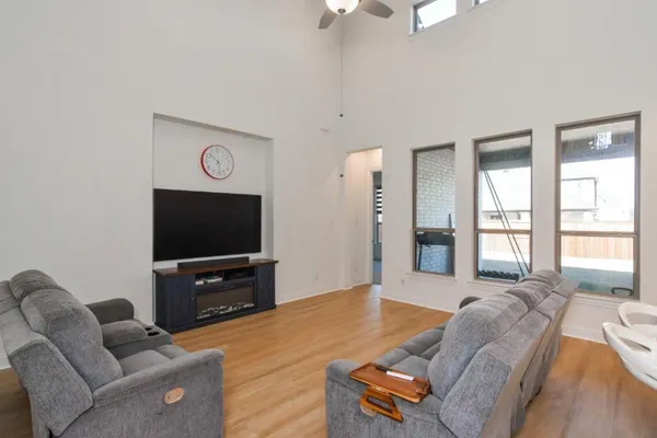 a living room with furniture a flat screen tv and a large window