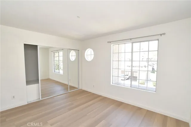 an empty room with wooden floor and windows