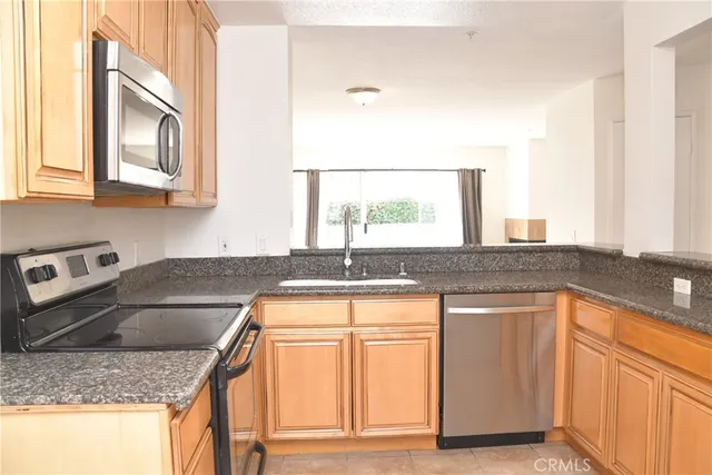 a kitchen with stainless steel appliances granite countertop a sink stove and cabinets