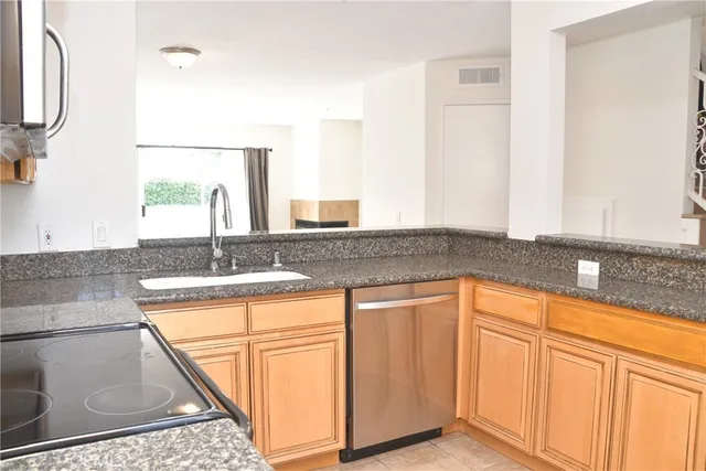 a kitchen with granite countertop a sink and a stove