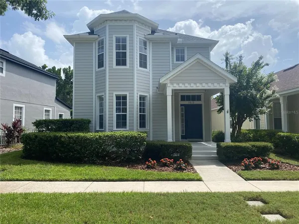 a front view of a house with a yard and potted plants