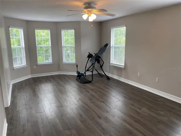 a view of a room with wooden floor gym equipment and windows