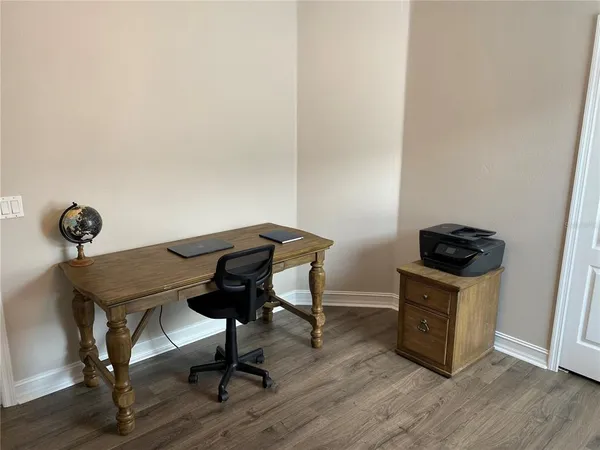 a view of a workspace with furniture and wooden floor