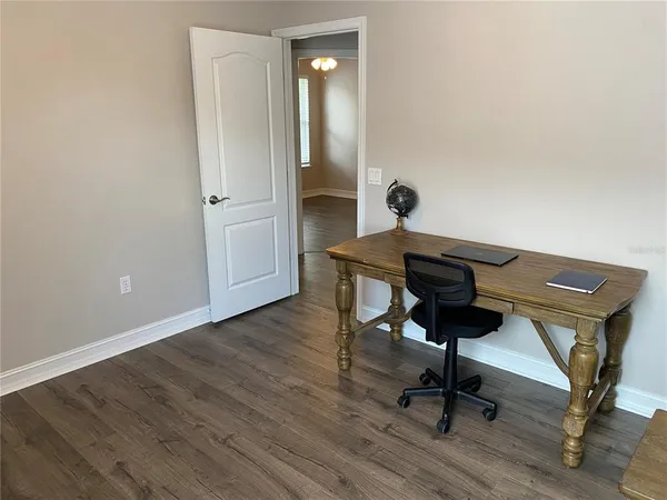 a view of a workspace with furniture and wooden floor
