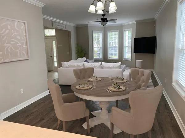 a view of a dining room with furniture wooden floor and chandelier