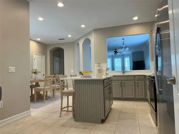 a kitchen with a sink and chairs