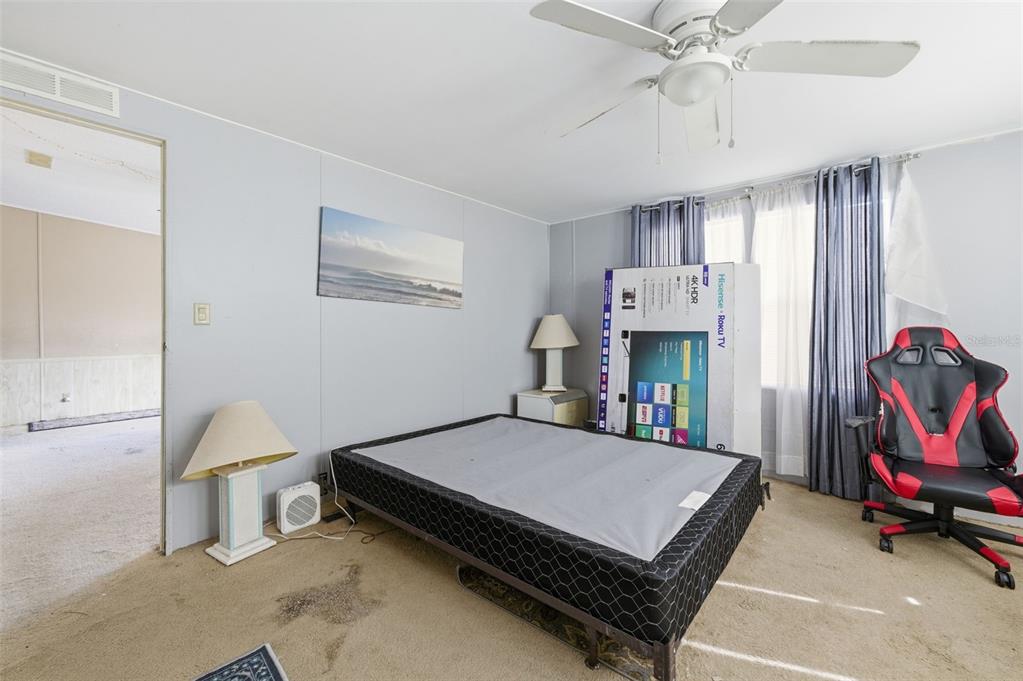 8045 Indian Trail Road Weeki Wachee, FL 34613 - Photo 3 of 49 a bedroom with furniture and a chandelier