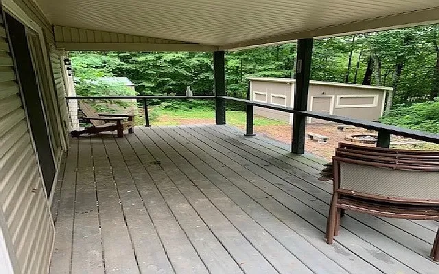 a view of a patio with table and chairs a wooden floor with a floor to ceiling window