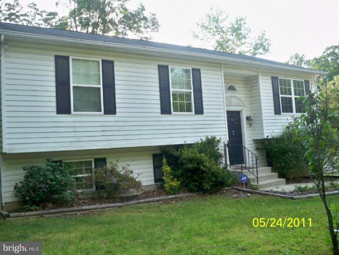 11555 Big Sandy Run Road Lusby, MD 20657 - Photo 1 of 3 a front view of a house with a yard