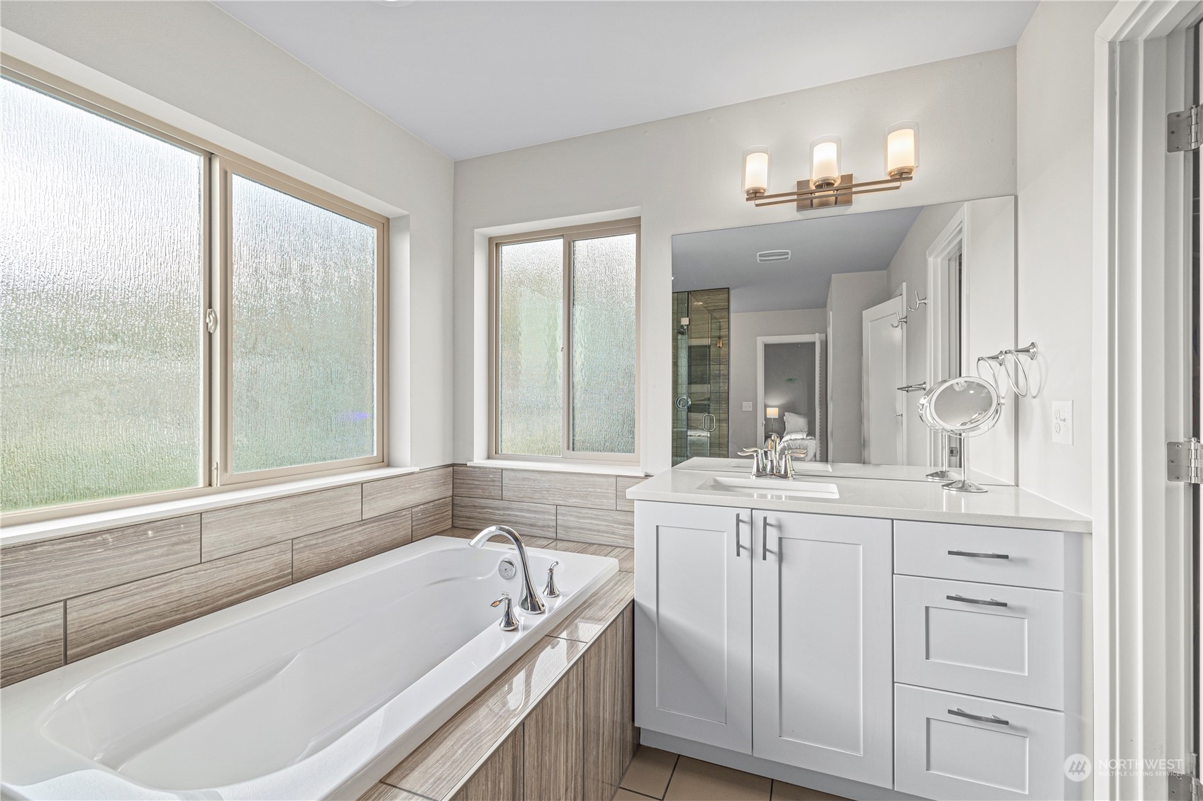 16614 Sylvester Road Southwest Burien, WA 98166 - Photo 25 of 40 a bathroom with a bathtub a sink a vanity and a large window