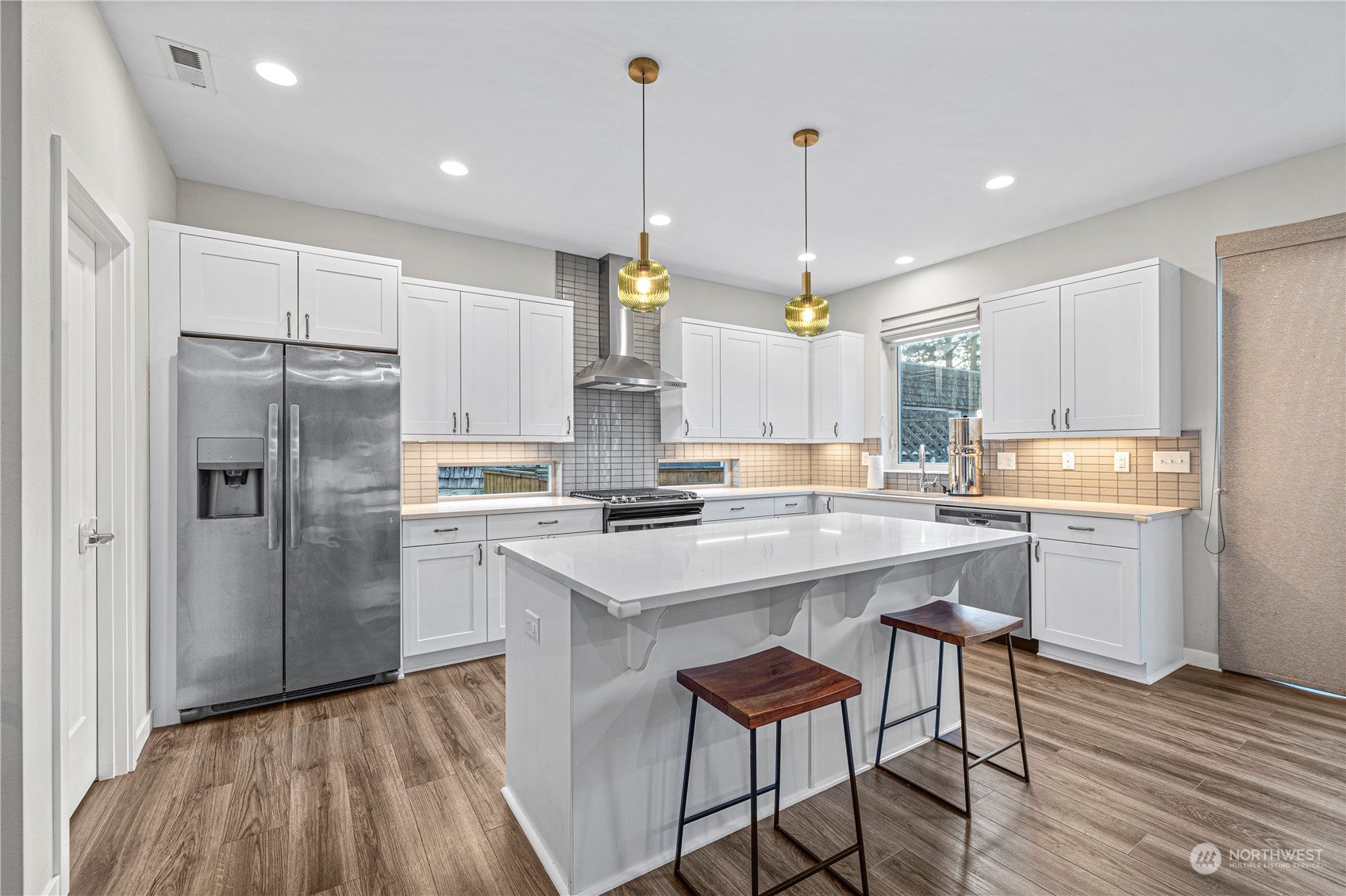 16614 Sylvester Road Southwest Burien, WA 98166 - Photo 9 of 40 a kitchen with stainless steel appliances granite countertop a refrigerator a sink dishwasher a stove and white cabinets with wooden floor