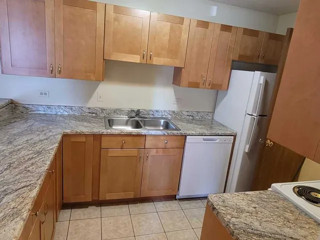 a kitchen with granite countertop a sink stove and cabinets