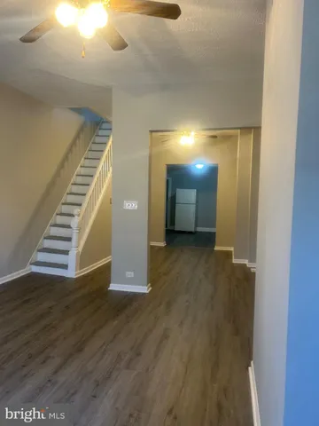 a view of a livingroom with wooden floor and stairs