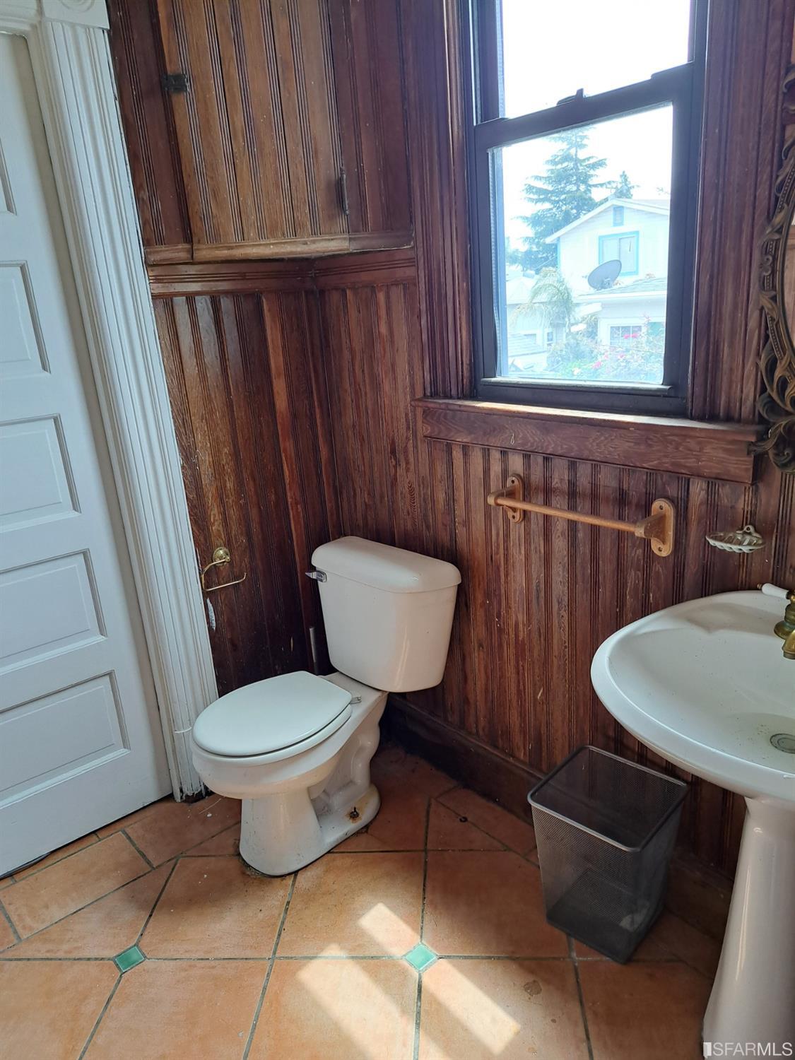 1930 55th Avenue Oakland, CA 94621 - Photo 15 of 25 a bathroom with a toilet a sink and a window