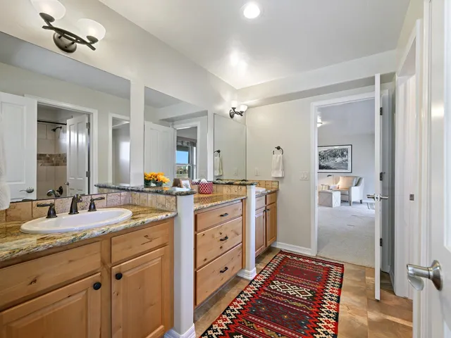 a spacious bathroom with a double vanity sink and mirror