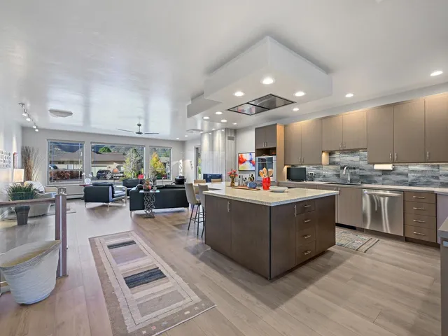 a kitchen with stainless steel appliances kitchen island granite countertop a stove and a refrigerator